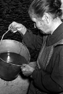 Maria Rabionet, de can Puriol, amb una galleda amb pressumpte petroli trobat a Amer. 29 d'agost de 1957