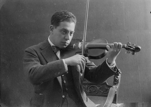 Retrat d'estudi del músic i compositor Josep Gravalosa Geronés (Santa Coloma de Farners 23/07/1882 - Sant Feliu de Guíxols 24/09/1975) tocant el violí. 1925-1930