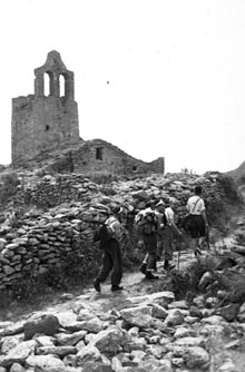 Excursionistes del GEiEG. En segon terme l'església de Santa Helena de Rodes. 1940